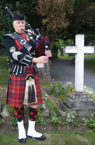 Jim Nicholl plays the bagpipes at a funeral service